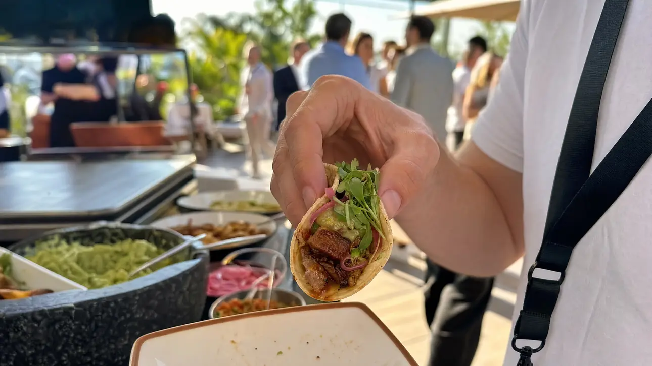 Guest holding a freshly filled taco at the club buffet